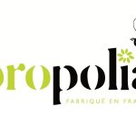 Propolia- brändin logo. Valkoisella pohjalla Propolia- teksti, jossa piirretty mehiläisen kuva.